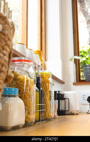 Vorratsdosen für Lebensmittel auf Fensterbank und Arbeitsplatte mit Geräten in der Küche, Kopierraum Stockfoto