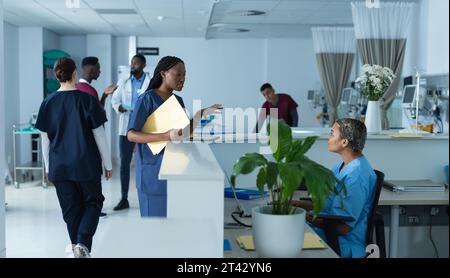 Diverse Ärztinnen diskutieren über die Arbeit an der Rezeption im Krankenhaus Stockfoto