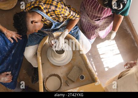 afroamerikanischer Töpfer, der mit Töpferrad an Tonvase arbeitet Stockfoto