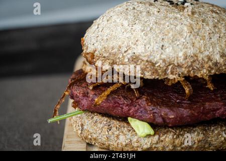Nahaufnahme eines Rote-Bete-Bohnen-Burgers mit gebratener Zwiebel Stockfoto