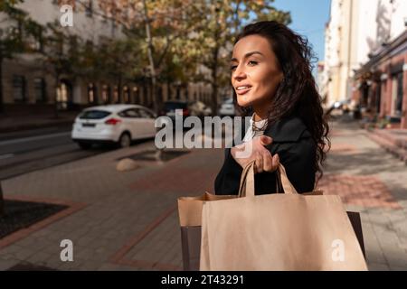 Lächelnde Frau, die auf der Straße mit Einkaufstaschen steht, Weißrussland Stockfoto
