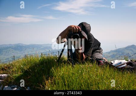 Fotograf, der ein Foto mit einem Stativ macht, Schweizer Alpen, Schweiz Stockfoto