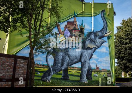 Trzebiatow, Polen - 18. September 2023: Grünes Wandbild mit Elefanten an der Mauer im historischen Stadtzentrum. Stockfoto