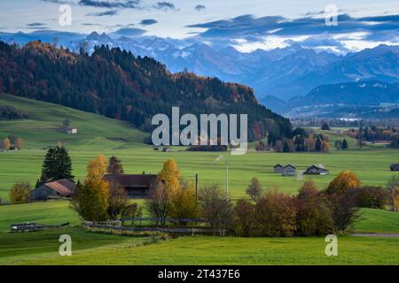 Landschaft im Allgäu bei Rettenberg. Schneebedeckte Berge. Nach Sonnenuntergang. Bauernhöfe und Häuser. Bayern, Deutschland. Bild aus öffentlichem Boden. Stockfoto