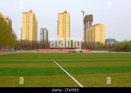 LUANNAN COUNTY - 10. APRIL: Spielplatz und umliegende Hochhäuser in einer Schule, am 10. April 2014, Luannan County, Provinz hebei, China. Stockfoto