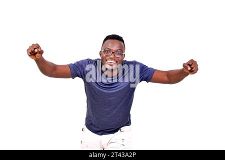 Ein gutaussehender Mann in Brille, der auf weißem Hintergrund läuft, der Siegesgesgesen macht und die Kamera lacht ansieht. Stockfoto