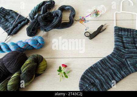 Set zum Handstricken warmer Wintersocken aus natürlichem Wollgarn auf einem Holztisch. Stockfoto