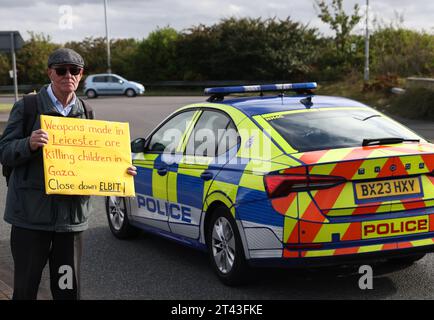 Leicester, Leicestershire, Großbritannien. Oktober 2023. Ein Demonstrant trägt ein Banner, das die Schließung von Elbit während einer pro-palästinensischen Demonstration fordert, und einen Banner-Drop in der Nähe der Basis der taktischen UAV-Systeme. ElbitÕs UAV Tactical Systems ist ein israelisch-französisches Unternehmen, das Drohnen herstellt, die an die britische Armee, Israel und internationale Waffenmärkte verkauft werden. Credit Darren Staples/Alamy Live News. Stockfoto