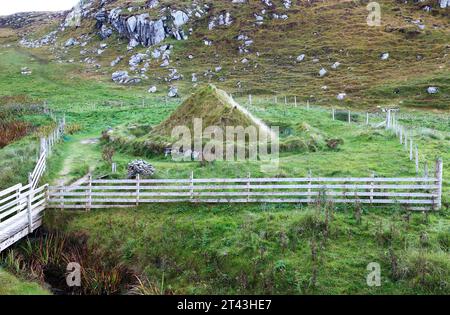 Ein Blick auf ein Nachbau des eisenzeitlichen Hauses mit Design, das auf dem nahe gelegenen eisenzeitlichen Dorf basiert, am Bosta Beach, Great Bernera, Äußere Hebriden, Schottland. Stockfoto