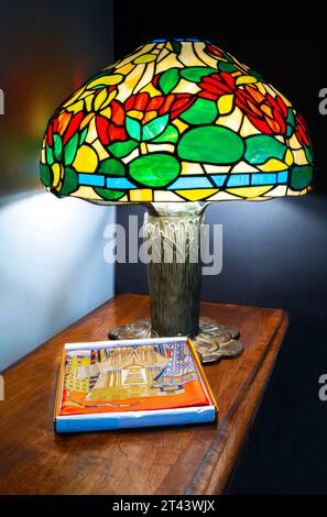 Reproduktion Tiffany-Lampe mit Acrylschirm und Hermes Schal auf einer Cherrywood-Tischplatte. Stockfoto