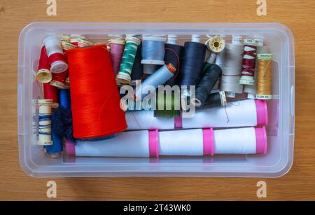 Eine Schachtel mit verschiedenen Fadenspulen zum Nähen. Stockfoto