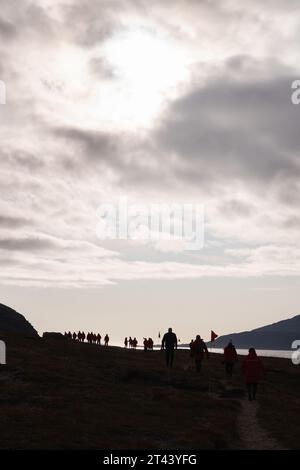 Grönland Touristen - Touristen Expedition Kreuzfahrtschiff Passagiere gehen in dramatische Landschaft und Himmel, Uunartoq, Südgrönland, Arktis. Stockfoto