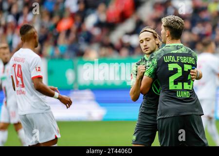 28. Oktober 2023, Bayern, Augsburg: Fußball, Bundesliga, FC Augsburg - VfL Wolfsburg, Spieltag 9, WWK Arena. Lovro Majer (2. Von rechts) und Jonas Older Wind (r) vom VfL Wolfsburg feiern Majers Ziel mit 1:2. Foto: Daniel Löb/dpa - WICHTIGER HINWEIS: Gemäß den Vorgaben der DFL Deutsche Fußball Liga und des DFB Deutscher Fußball-Bund ist es verboten, im Stadion und/oder des Spiels aufgenommene Fotografien in Form von Sequenzbildern und/oder videoähnlichen Fotoserien zu verwenden oder verwenden zu lassen. Stockfoto