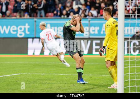 28. Oktober 2023, Bayern, Augsburg: Fußball: Bundesliga, FC Augsburg - VfL Wolfsburg, Spieltag 9, WWK Arena. Sebastiaan Bornauw vom VfL Wolfsburg (M) schnappt sich nach seinem eigenen Tor den Kopf, um es mit 2:2 zu erreichen, Torhüter Pavao Pervan (r) sieht entsetzt aus und Phillip Tietz vom FC Augsburg (l) dreht sich zu jubeln. Foto: Daniel Löb/dpa - WICHTIGER HINWEIS: Gemäß den Vorgaben der DFL Deutsche Fußball Liga und des DFB Deutscher Fußball-Bund ist es verboten, im Stadion und/oder des Spiels aufgenommene Fotografien in Form von Sequenzbildern und/oder videoähnlichen Fotoserien zu verwenden oder verwenden zu lassen. Stockfoto