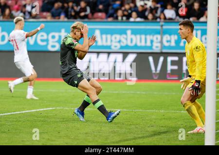 28. Oktober 2023, Bayern, Augsburg: Fußball: Bundesliga, FC Augsburg - VfL Wolfsburg, Spieltag 9, WWK Arena. Sebastiaan Bornauw vom VfL Wolfsburg (M) schnappt sich nach seinem eigenen Tor den Kopf, um es mit 2:2 zu erreichen, Torhüter Pavao Pervan (r) sieht entsetzt aus und Phillip Tietz vom FC Augsburg (l) dreht sich zu jubeln. Foto: Daniel Löb/dpa - WICHTIGER HINWEIS: Gemäß den Vorgaben der DFL Deutsche Fußball Liga und des DFB Deutscher Fußball-Bund ist es verboten, im Stadion und/oder des Spiels aufgenommene Fotografien in Form von Sequenzbildern und/oder videoähnlichen Fotoserien zu verwenden oder verwenden zu lassen. Stockfoto