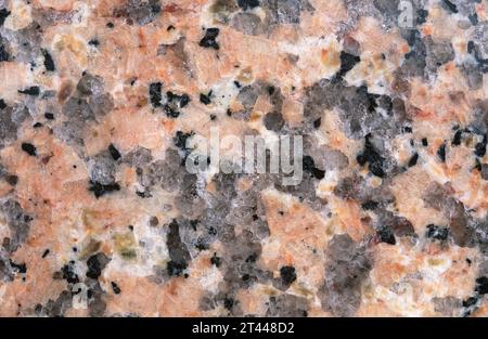 Rosafarbener Granit. Granit ist ein unheilvoller Intrusivgestein mit holokristalliner Textur. Polierte Oberfläche. Stockfoto