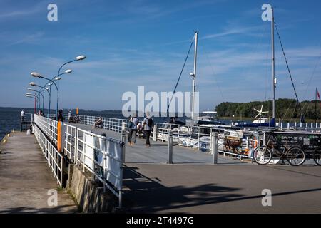 Kamien Pomorski, Polen - 14. September 2023: Menschen, die auf dem Kai in der Lagune von Kamien (Zalew Kamienski) spazieren. Stockfoto