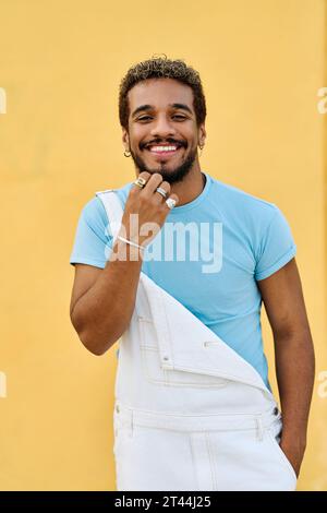 Junger lateinamerikanischer Mann, der mit der Hand am Kinn in die Kamera lächelt Stockfoto