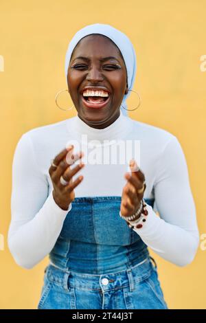 Vertikales Porträt einer afrikanischen muslimischen Frau, die glücklich lacht Stockfoto