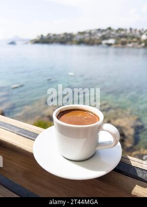 Kaffee, eine Tasse griechischer oder türkischer Kaffee auf dem Tisch über wunderschönem, ruhigem Meer und Himmel mit Kopierraum an einem sonnigen Sommertag in der Türkei. Traditionelles türkisches h Stockfoto