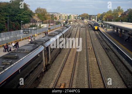 Zwei Züge, einer kommend, einer fährt, am Bahnhof Oxford mit Gleisen und Bahnsteigen, Großbritannien Stockfoto