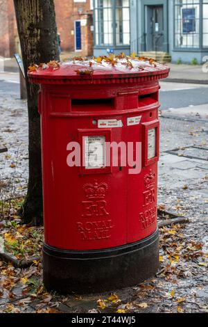 Traditioneller britischer Briefkasten aus Gusseisen, doppelter Postamt-Royal-Mail-Briefkasten oder Säulenbriefkasten, leuchtend rot lackiert Stockfoto