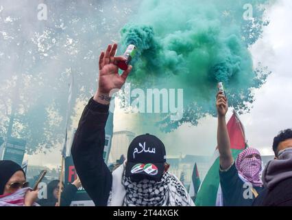 London, Großbritannien. Oktober 2023. Während der Demonstration in der Nähe der Westminster Bridge halten Demonstranten Rauchfackeln ab. Zehntausende von Menschen marschierten im Zentrum Londons in Solidarität mit Palästina, während sich der Krieg zwischen Israel und Hamas verschärft hat. Quelle: SOPA Images Limited/Alamy Live News Stockfoto