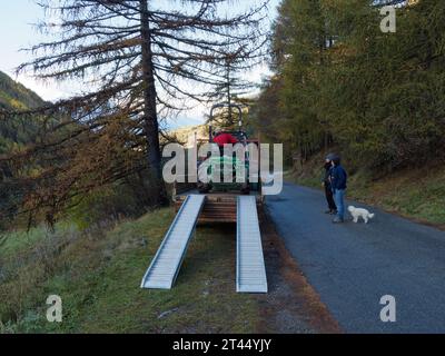 Entladung einer Maschine für die Kartoffelernte von einem Anhänger als Menschen an einem kalten Herbstmorgen im Aostatal NW Italien. Oktober 2023 Stockfoto