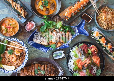 Abwechslungsreiches asiatisches Essen. Berühmte asiatische Gerichte auf dem Tisch. Draufsicht. Das Konzept eines thailändischen Restaurants. Bankett im asiatischen Stil Stockfoto