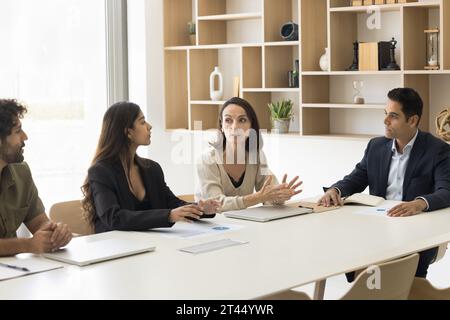 Ernsthafte, reife Geschäftsfrau, die Ideen mit Kollegen teilt Stockfoto