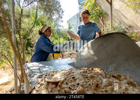 Türkische Frauen backen Brot im traditionellen Brotbackofen in einem Dorf Samandağ in der Provinz Hatay, Türkei Stockfoto