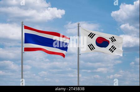 Südkorea oder Republik Korea oder ROK und Thailand Flaggen, die zusammen im Wind auf blauem bewölktem Himmel winken, zwei Länder-Beziehungskonzept Stockfoto