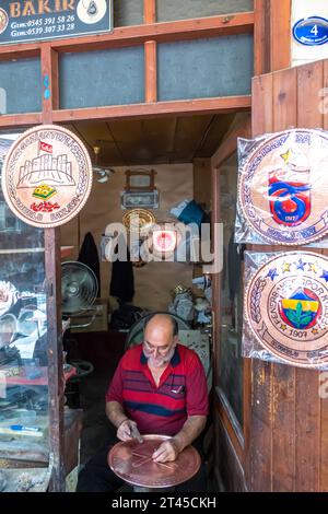 Ein Graveur, der die Kupferplatte mit einem Nagel in einem Verkaufsstand in Gaziantep in der Türkei graviert Stockfoto