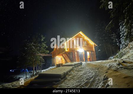 Wunderschönes Chalet im Winterwald bei Nacht Stockfoto
