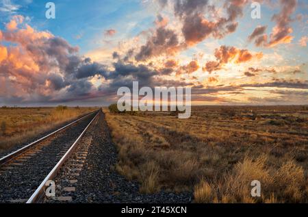 Eisenbahnüberquerung bei Sonnenuntergang in South Australia, Bullo Creek Stockfoto