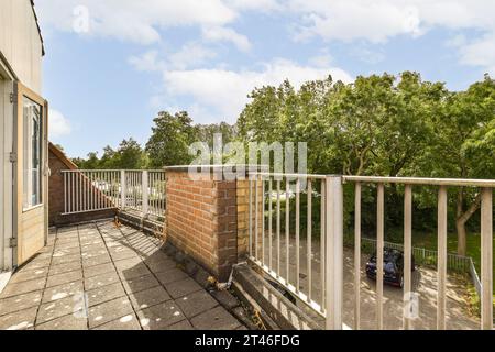 Ein Außenbereich mit Balkon und Bäumen im Hintergrund, von oben bis unten gesehen Stockfoto