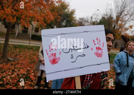 Bloomington, USA. Oktober 2023. Eine Frau hält ein Schild, als sich Demonstranten in Dunn Meadow an der Indiana University versammeln, um gegen die israelische Bodenoperation in Gaza am 28. Oktober 2023 in Bloomington, Indiana, zu protestieren. Die Kundgebung trug den Titel: „Steht mit Gaza. Versammeln und trauern um das unschuldige Leben der Palästinenser.“ (Quelle: Jeremy Hogan/Alamy Live News Stockfoto