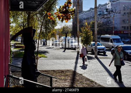 Frauen gehen am Eingang des Cafés mit Halloween-Dekorationen in Zaporischzhia vorbei. Halloween keltischer Herkunft kam nach dem Zusammenbruch der Sowjetunion in die Ukraine. Von dieser Zeit an übernahmen die Ukrainer die Tradition aus anderen Ländern, gruselige Kostüme zu tragen, das Hauptmerkmal dieses Urlaubs - den Kürbis - auszuschneiden und die Bonbons unter den Nachbarn zu sammeln. Die moderne orthodoxe Kirche verurteilt diesen Feiertag noch immer, aber jedes Jahr gibt es in der Ukraine immer mehr junge Menschen, die nicht dagegen sind, für eine Nacht auf die Seite des Bösen zu gehen. (Foto: Andriy Andriyenko/SOPA Ima Stockfoto