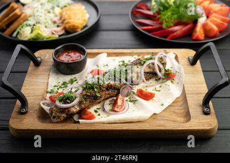 Lula-Kebab mit Gemüse und Pita-Brot auf einem Holzbrett im Restaurant. Arabische Küche Stockfoto