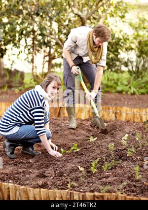 Porträt, Frau und Pflanze im Boden für Gemüsegarten mit Mann für natürliche, biologische oder frische Produkte. Leute, Freunde und dich anschauen Stockfoto