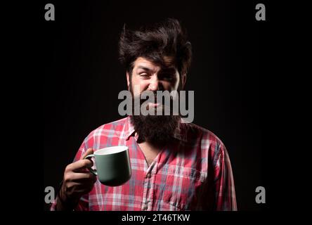 Happy Morning. Mans hält eine Tasse Kaffee. Morgentee. Guten Morgen. Mann mit Teetasse. Hipster-Mann mit einer Tasse Kaffee. Bärtiger Mann, der lächelt, hält Tasse Tee Stockfoto