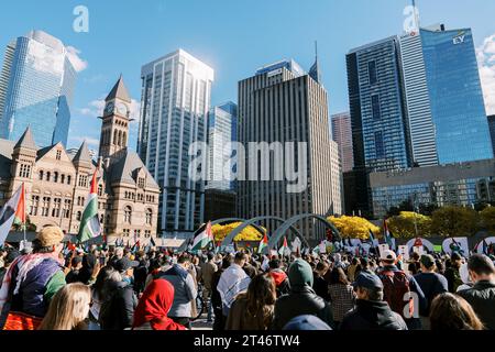 Toronto, Kanada - 28. Oktober 2023: Demonstranten versammeln sich auf einem Stadtplatz, die Flaggen wehen, mit ikonischen Gebäuden, die den Hintergrund unter klarem Himmel bilden Stockfoto