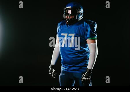Ein asiatischer Mann mit rotem Bart in blauer American Football-Uniform im Studio. Stockfoto