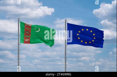 Die Fahnen der Europäischen Union und Turkmenistans schwenken zusammen im Wind auf blauem bewölktem Himmel, Beziehungskonzept Stockfoto