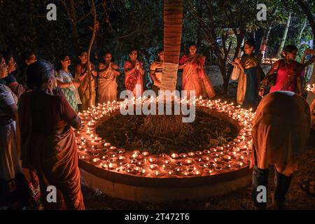 Mumbai, Indien. Oktober 2023. Frauen bilden einen Kreis und beten in der Nähe der irdenen Lampen, die anlässlich der Sharad Purnima (Vollmond) in Mumbai beleuchtet werden. Sharad Purnima oder der Vollmond markiert das Ende der Monsunsaison und wird von den Hindus in ganz Südasien in den Monaten September bis Oktober auf vielfältige Weise gefeiert. Gläubige beobachten in der Vollmondnacht schnell. Lakshmi, Göttin des Reichtums, wird an diesem Tag verehrt, da es ihr Geburtstag sein soll, und zu ihr zu beten bringt Glück und Reichtum. Quelle: SOPA Images Limited/Alamy Live News Stockfoto