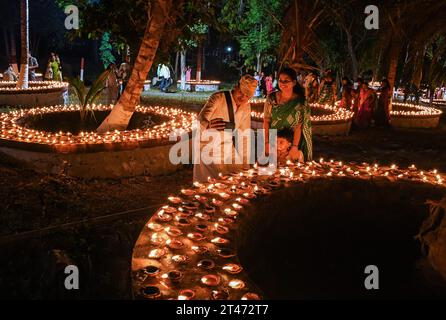 Mumbai, Indien. Oktober 2023. Die Menschen machen ein Selfie in der Nähe der Erdlampen, die anlässlich von Sharad Purnima (Vollmond) in Mumbai beleuchtet werden. Sharad Purnima oder der Vollmond markiert das Ende der Monsunsaison und wird von den Hindus in ganz Südasien in den Monaten September bis Oktober auf vielfältige Weise gefeiert. Gläubige beobachten in der Vollmondnacht schnell. Lakshmi, Göttin des Reichtums, wird an diesem Tag verehrt, da es ihr Geburtstag sein soll, und zu ihr zu beten bringt Glück und Reichtum. Quelle: SOPA Images Limited/Alamy Live News Stockfoto