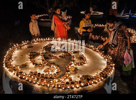 Mumbai, Indien. Oktober 2023. Menschen werden um die Erdlampen herum gesehen, die anlässlich des Sharad Purnima (Vollmond) in Mumbai beleuchtet wurden. Sharad Purnima oder der Vollmond markiert das Ende der Monsunsaison und wird von den Hindus in ganz Südasien in den Monaten September bis Oktober auf vielfältige Weise gefeiert. Gläubige beobachten in der Vollmondnacht schnell. Lakshmi, Göttin des Reichtums, wird an diesem Tag verehrt, da es ihr Geburtstag sein soll, und zu ihr zu beten bringt Glück und Reichtum. Quelle: SOPA Images Limited/Alamy Live News Stockfoto