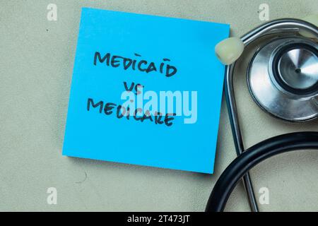 Medicaid vs. Medicare schreiben auf Haftnotizen isoliert auf Holztisch. Stockfoto