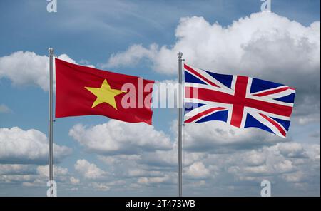 Britische und vietnamesische Flaggen winken zusammen im Wind auf blauem bewölktem Himmel, zwei Länder-Beziehungskonzept Stockfoto