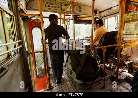 Ein Mann unterhält sich mit dem örtlichen Busfahrer, während er die hügeligen Straßen in Sri Lanka überquert Stockfoto